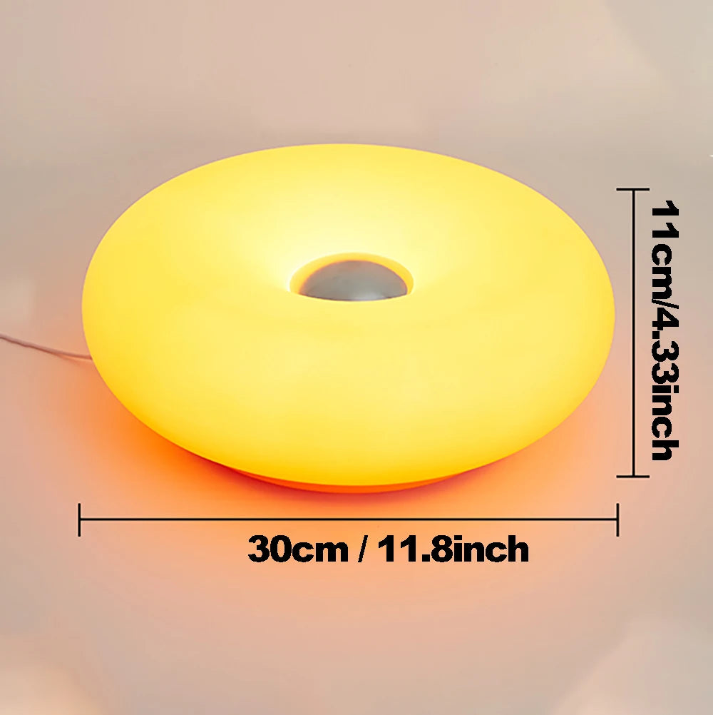 Modern round ambient table lamp with warm yellow glow, 30cm wide, 11cm tall