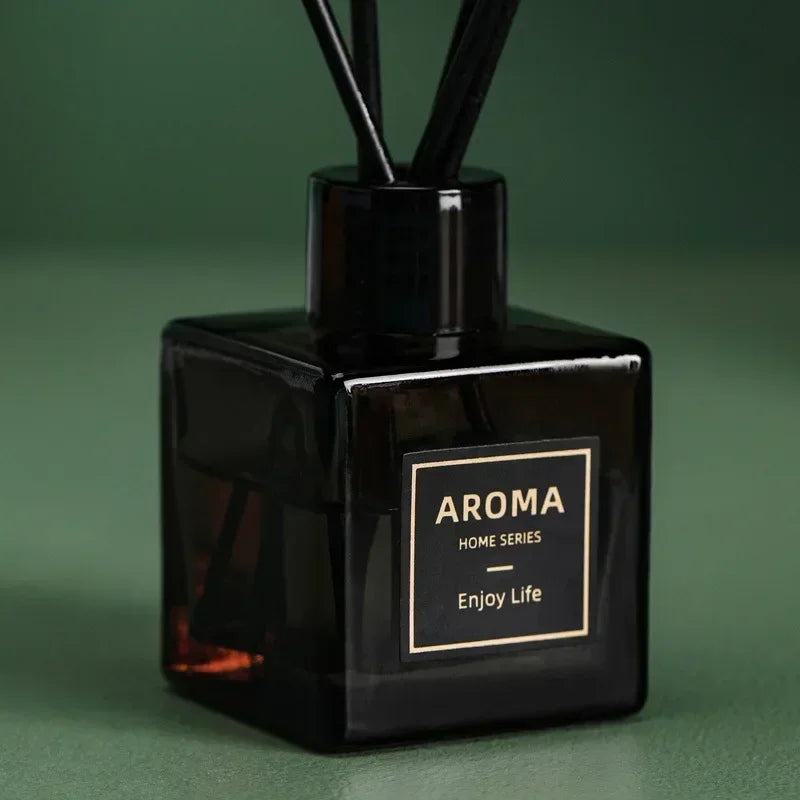 Black aroma diffuser bottle with reeds, labeled 'Aroma Home Series Enjoy Life' on green background