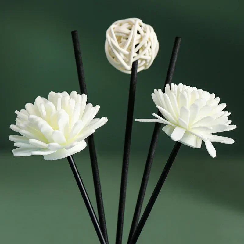 White sola flower diffuser sticks and rattan ball against a green background